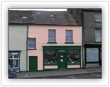 Terraced three-bay two-storey house, built c. 1820, with attic, also in use as shop, with attic and with multiple-bay two-storey extension to rear having pitched slate roof.