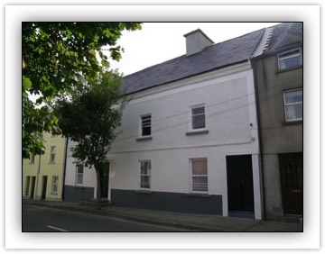Terraced four-bay two-storey over basement house, built c.1780, with full-height stairs return to rear, having one storey lower addition to west giving external access to basement