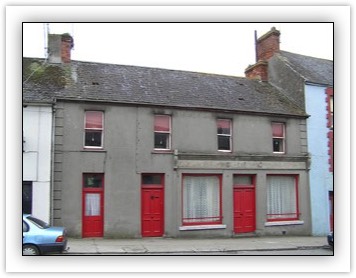 Terraced four-bay two-storey house, built c. 1900, with disused shopfront